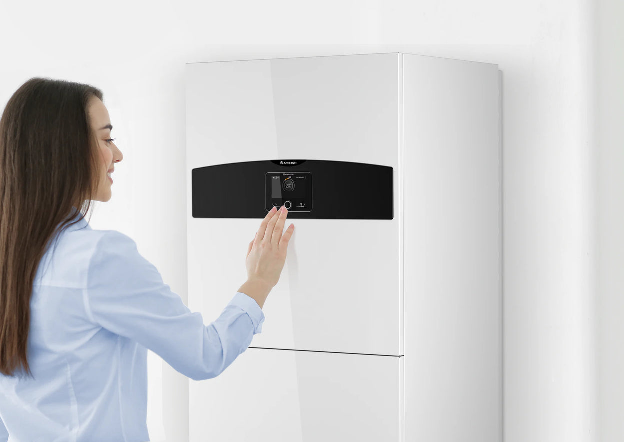 Žena koristi kontroler na unutrašnjoj jedinici Ariston Compact toplotne pumpe